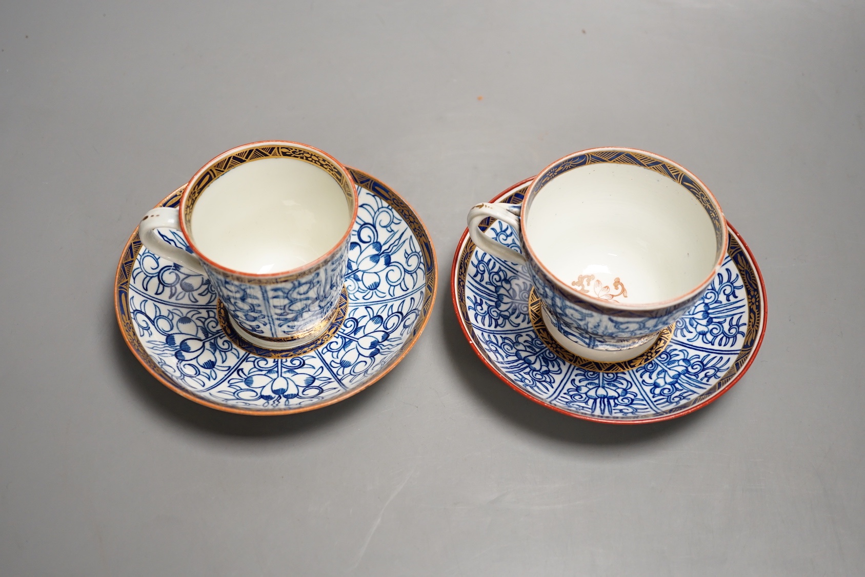 A Worcester coffee cup and saucer of rare Sevres shape with entwined handle painted with the Royal Lily pattern with an unusual central design and a Worcester conical coffee cup and saucer painted with another version of